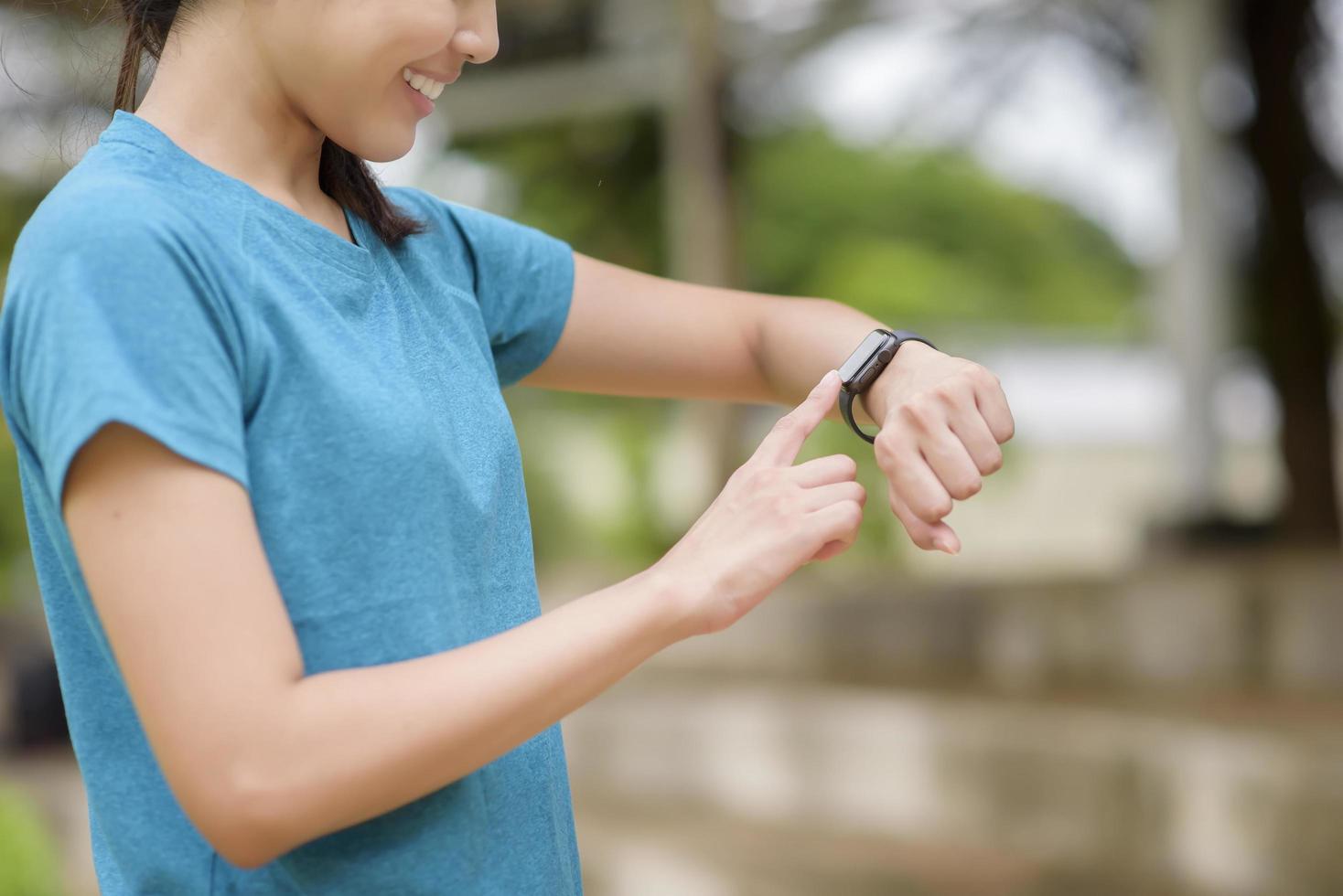 heureuse jeune femme à l'aide de smart watch photo