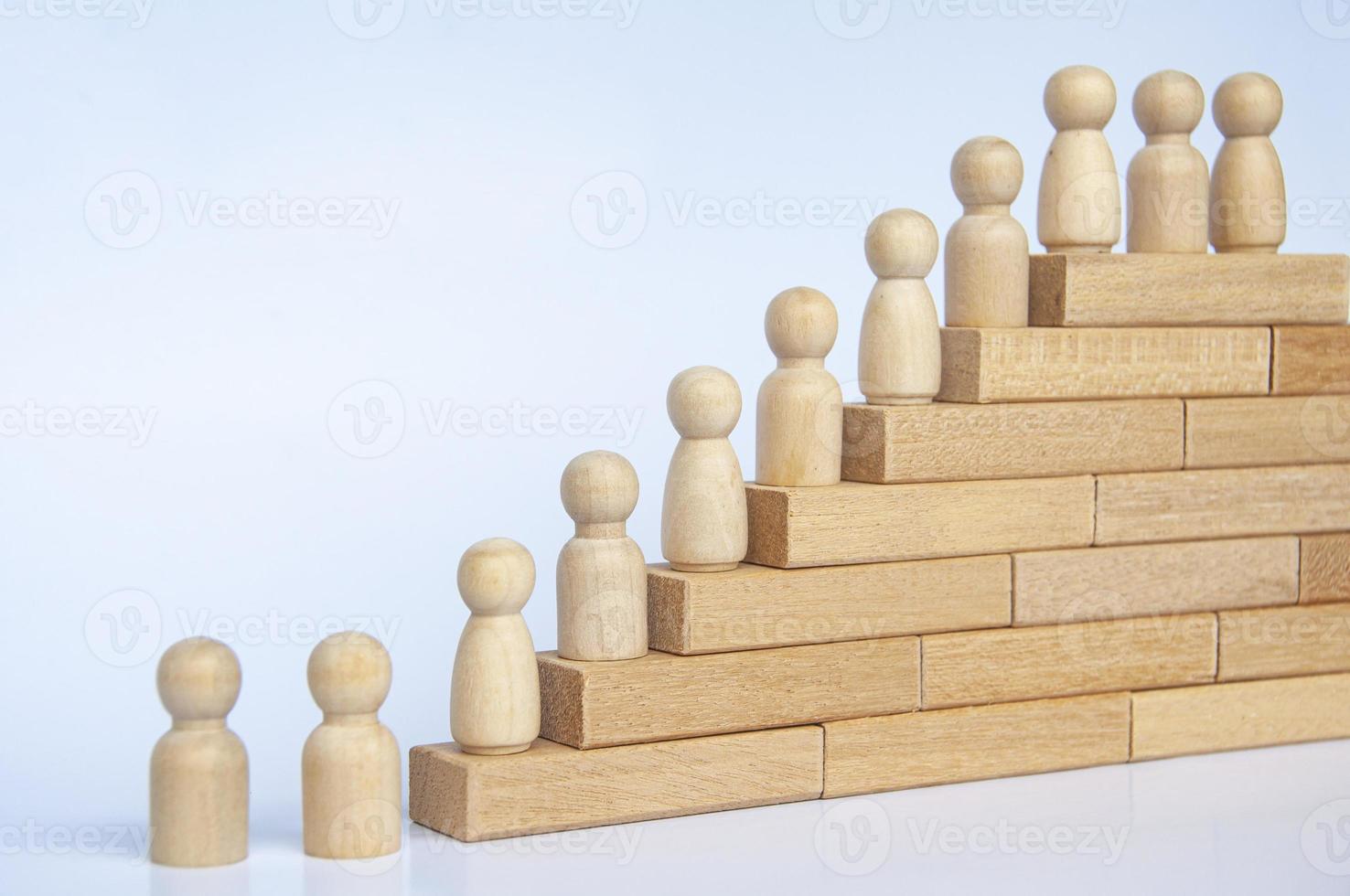 des personnages en bois figurent sur des blocs de bois. la réalisation des objectifs, la croissance de l'entreprise et la progression de carrière. espace de copie. photo