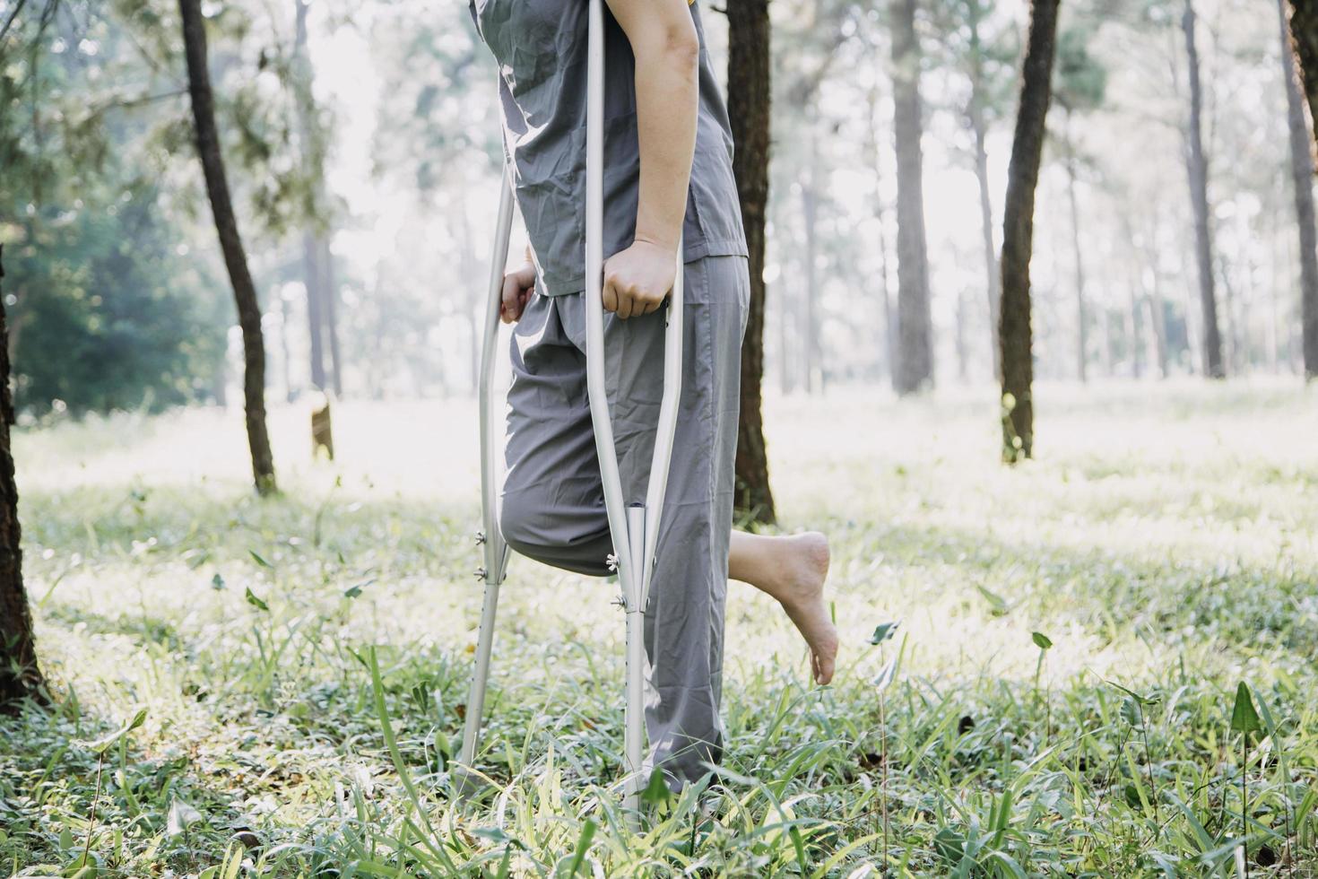 jeune physiothérapeute asiatique travaillant avec une femme âgée sur la marche avec un déambulateur photo