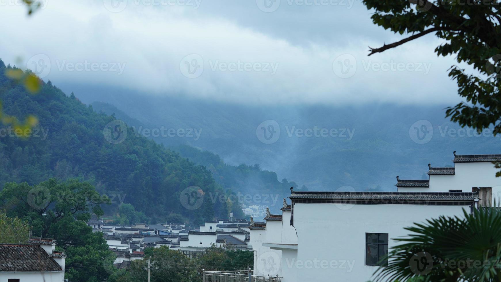 la belle vue sur le village chinois traditionnel avec l'architecture classique et les arbres verts frais en arrière-plan photo