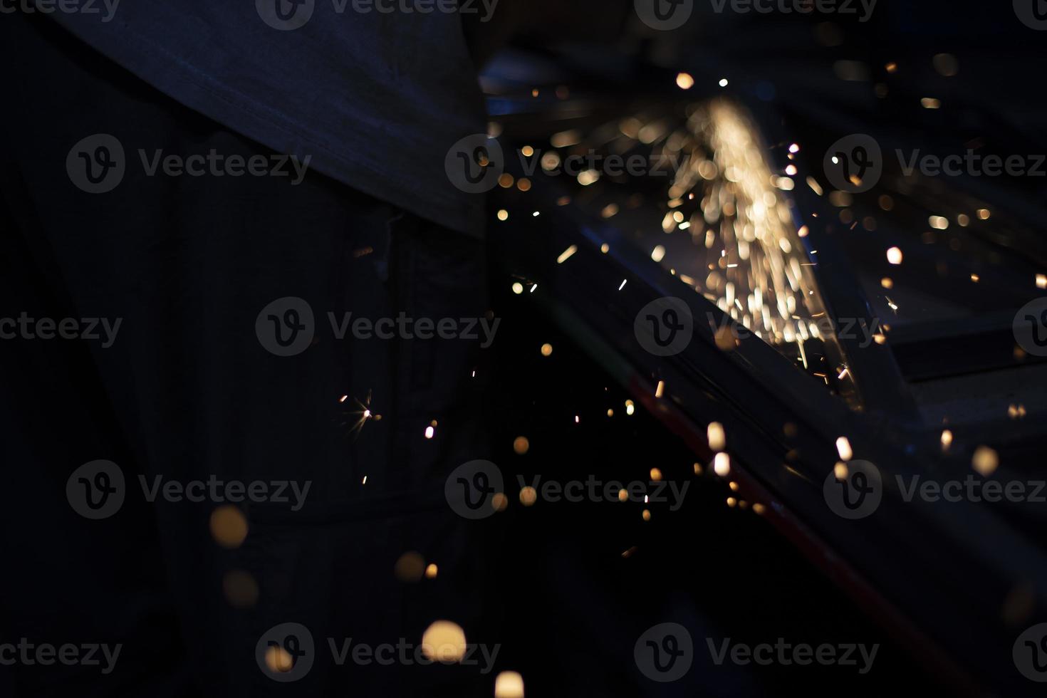 broyage des métaux. étincelles de frottement. lumières dans l'obscurité. vol chaotique de tir partiel. photo