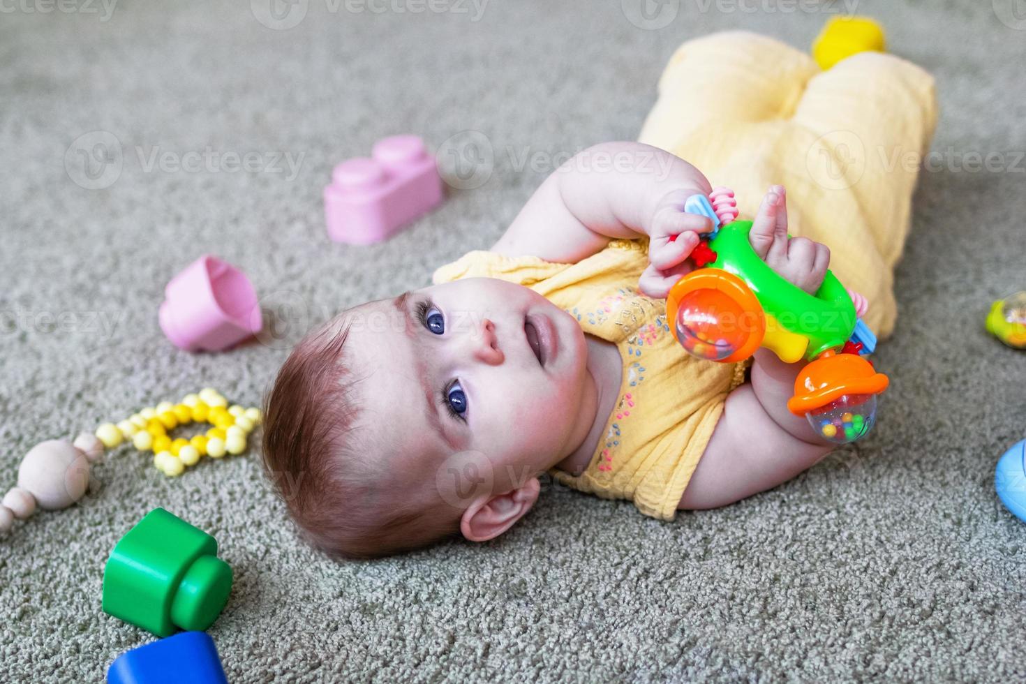 jolie petite fille allongée sur le sol et jouant avec des jouets en  plastique et en bois colorés. développer la motricité de l'enfant. 13396016  Photo de stock chez Vecteezy