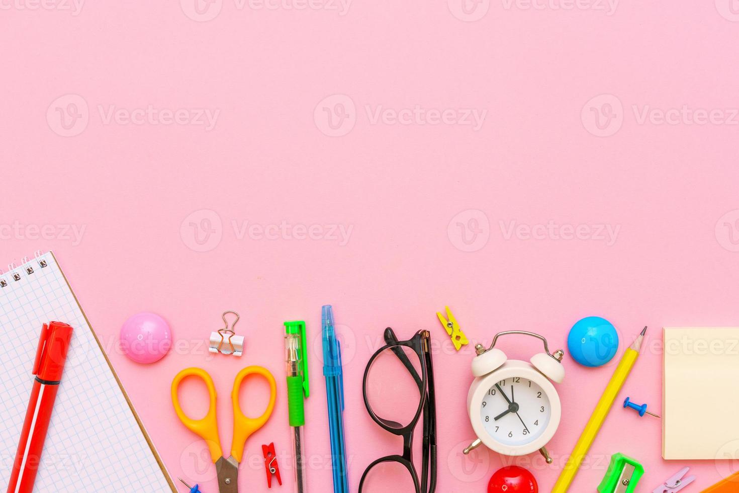 cahier d'école et fournitures de bureau sur fond rose. retour à l'école photo