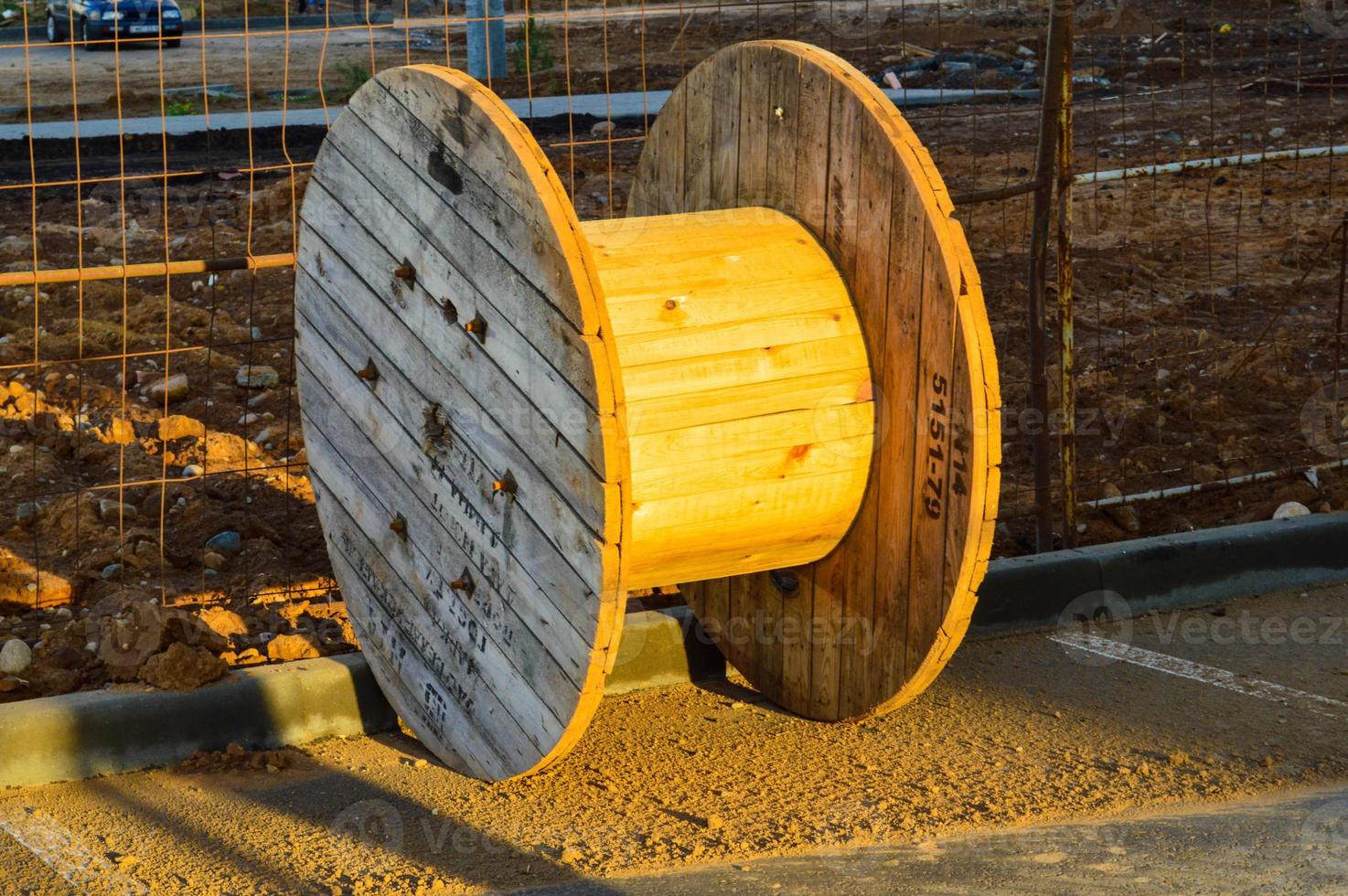 grande bobine lisse en bois pour enrouler un fil ou un câble haute tension. bobine en bois jaune, enroulement de fil. outil pour l'électricité. chantier de construction photo