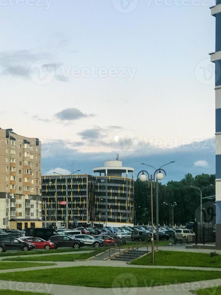 parking jaune vif est dans la cour. rond, à côté d'un immeuble résidentiel beige. espace de stockage pour les voitures et les pommes de terre. entraînement rond pour différentes voitures, charpente métallique du bâtiment photo