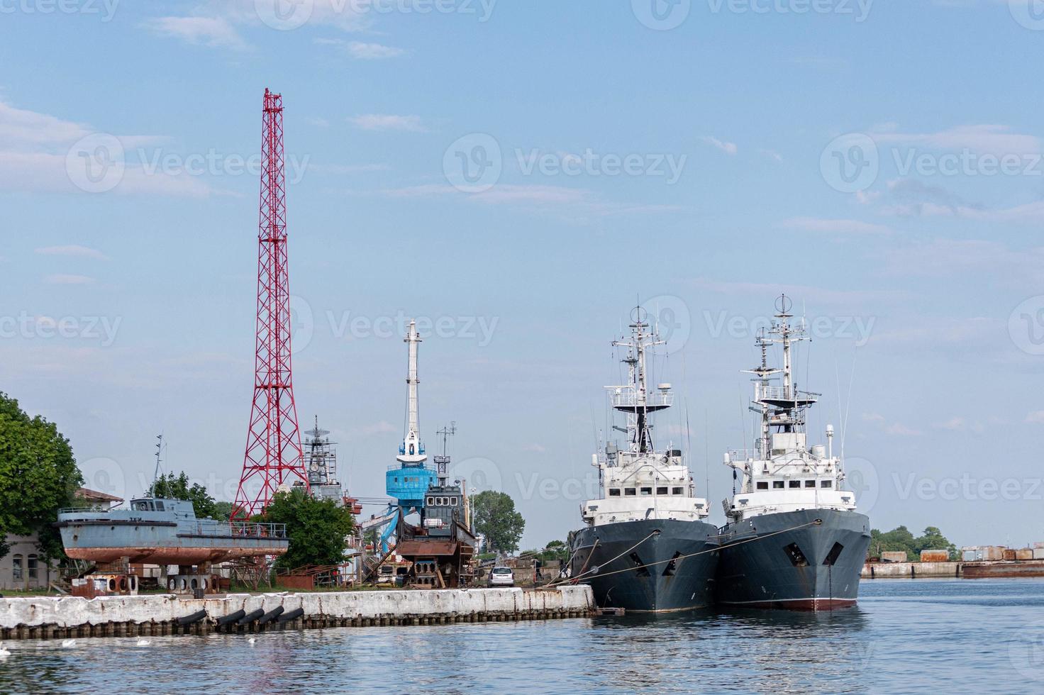 grands navires de la marine de fer dans le chantier naval pour réparation. grande grue dans l'arsenal. port de la mer bleue. mouillage des navires photo