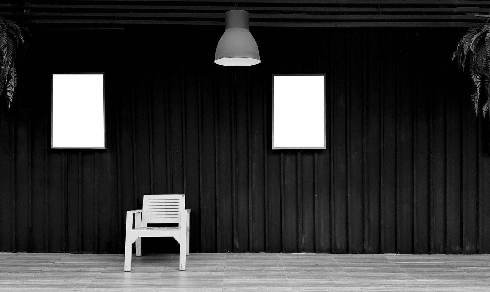 chaise en bois avec deux cadres photo ou maquette et espace de copie pour ajouter du texte ou du texte sur fond d'obturateur noir en noir et blanc. mur sombre et lumière suspendue et vigne, plante grimpante. design d'art