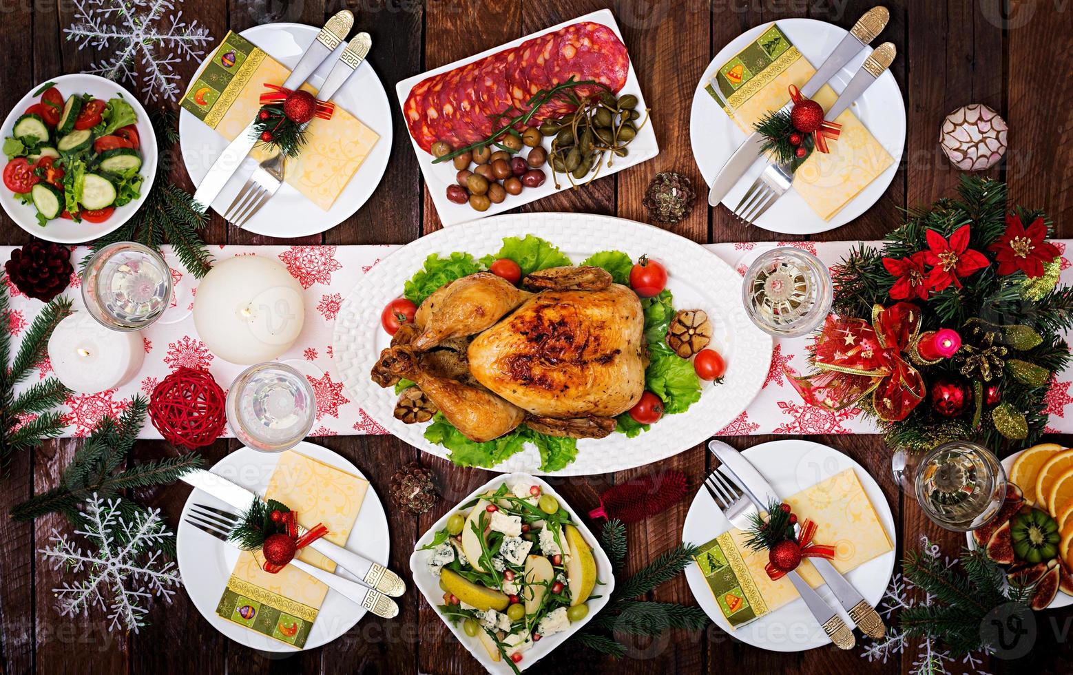 dinde ou poulet au four. la table de noël est servie avec une dinde, décorée de guirlandes lumineuses et de bougies. poulet frit, table. dîner de Noël. mise à plat. vue de dessus photo