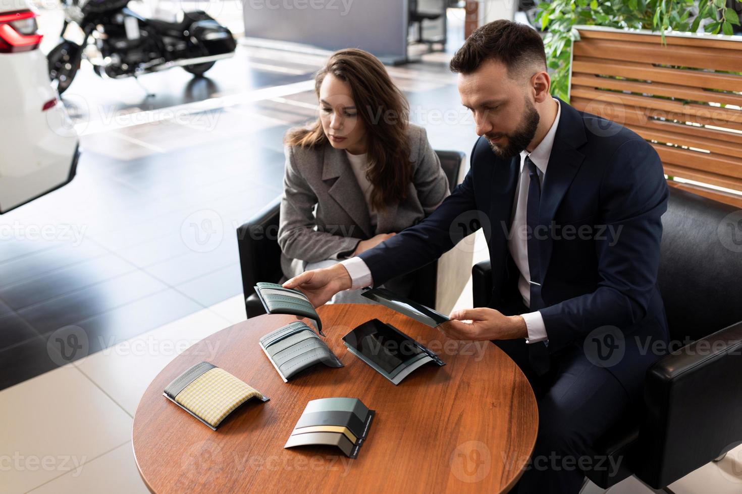 une jeune femme est déterminée à la décoration intérieure d'une nouvelle voiture lors de son achat chez un concessionnaire automobile photo