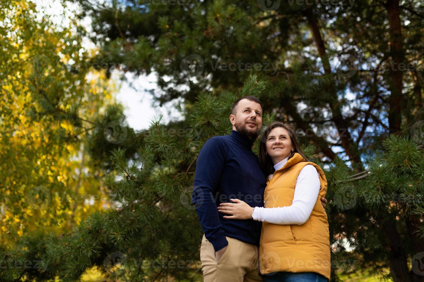 heureux couple marié étreignant dans la forêt d'automne photo