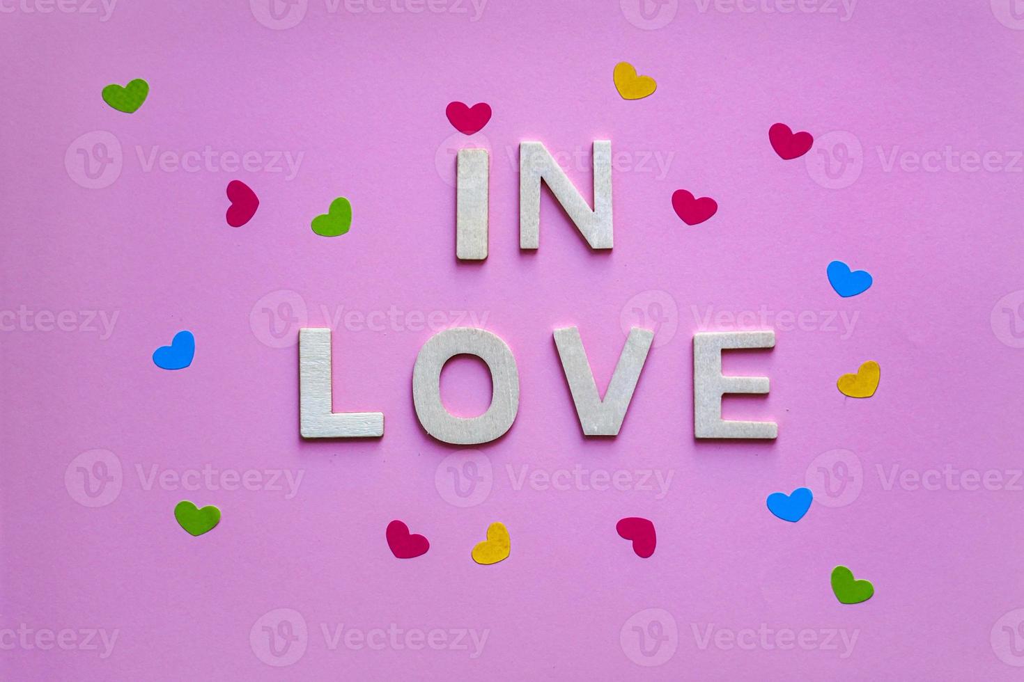 mot d'amour avec des lettres en bois sur fond rose, saint valentin photo