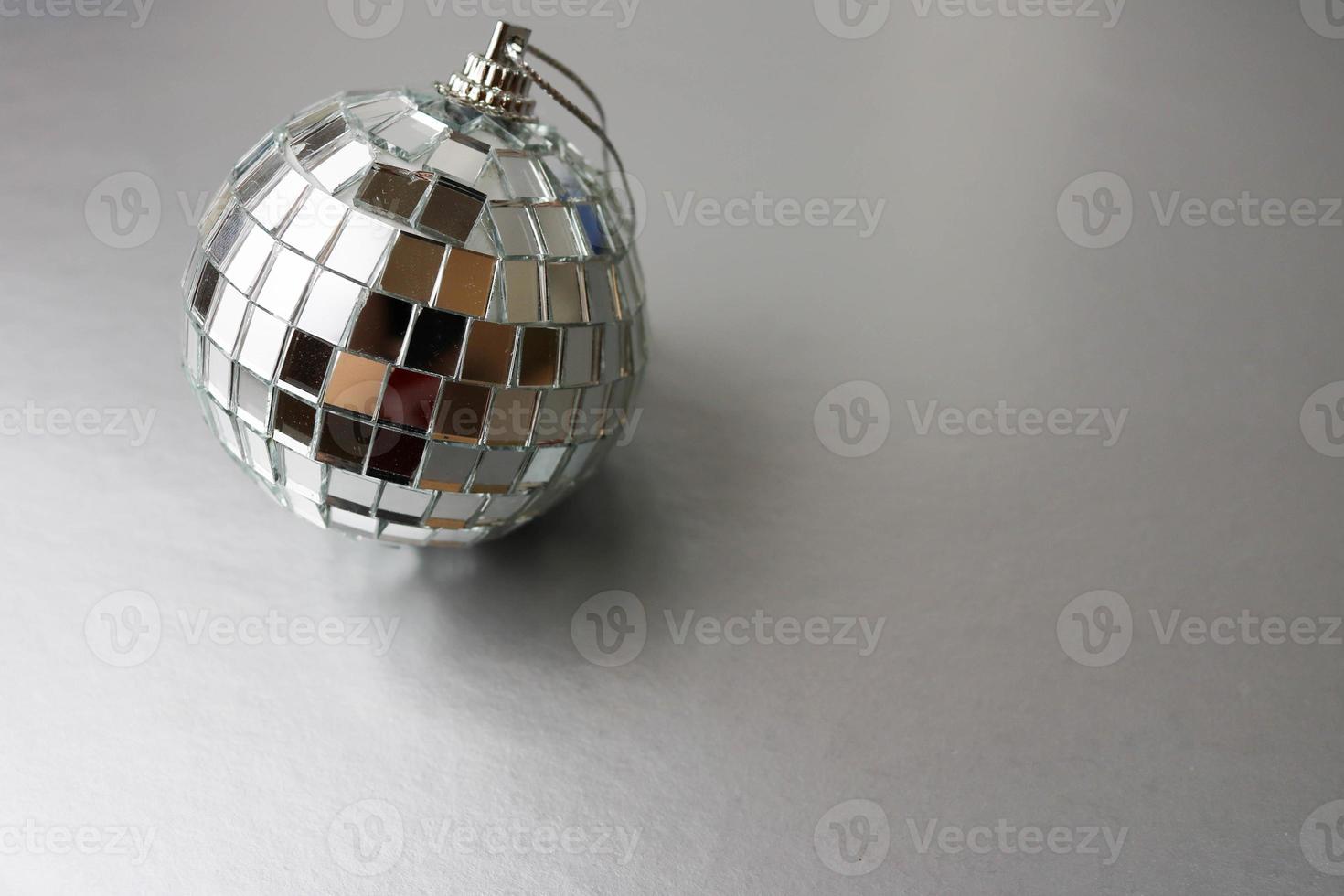miroir argenté club de musique boule disco petit verre rond hiver brillant décoratif belle boule de noël festive de noël, jouet de noël collé sur des étincelles sur fond noir et blanc photo