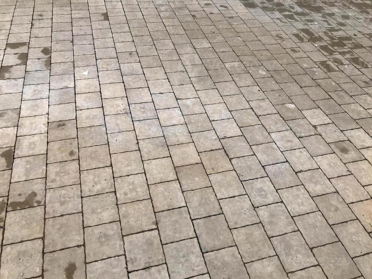 asphalte gris, briques de béton qui ont pavé la route vers le centre commercial. surface de la route améliorée. commodité des sentiers pédestres pour la circulation des personnes et des cyclistes photo