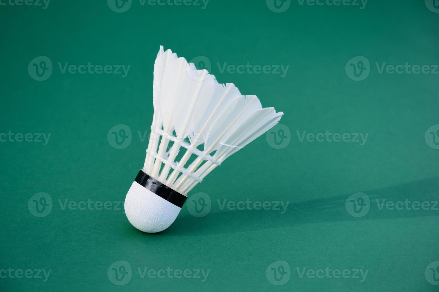 volant de badminton blanc crème et raquette au sol dans un terrain de badminton intérieur, espace de copie, mise au point douce et sélective sur les volants. photo