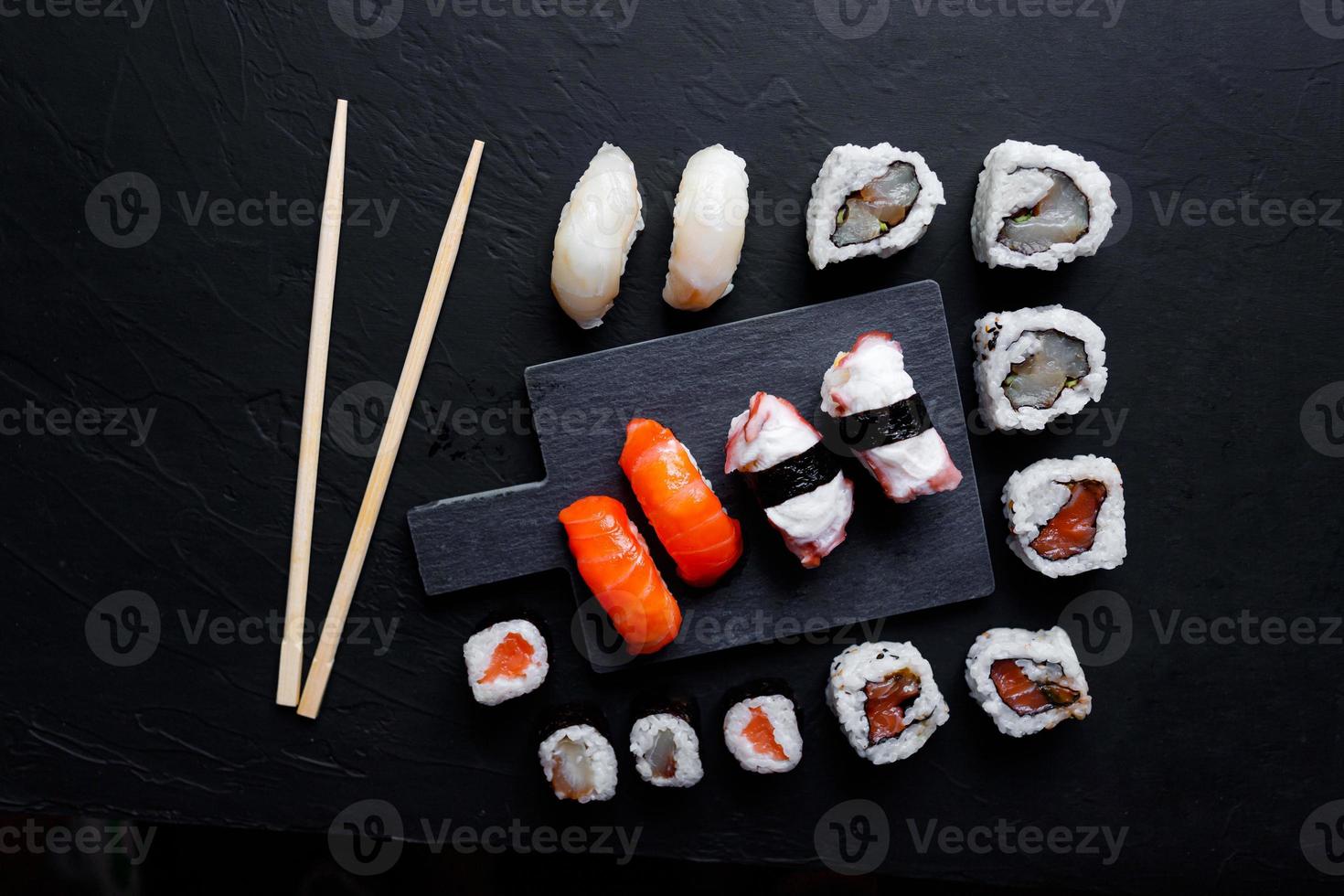 nourriture japonaise de sushi. maki ands rolls au thon, saumon, crevette, crabe et avocat. vue de dessus de sushis assortis. photo