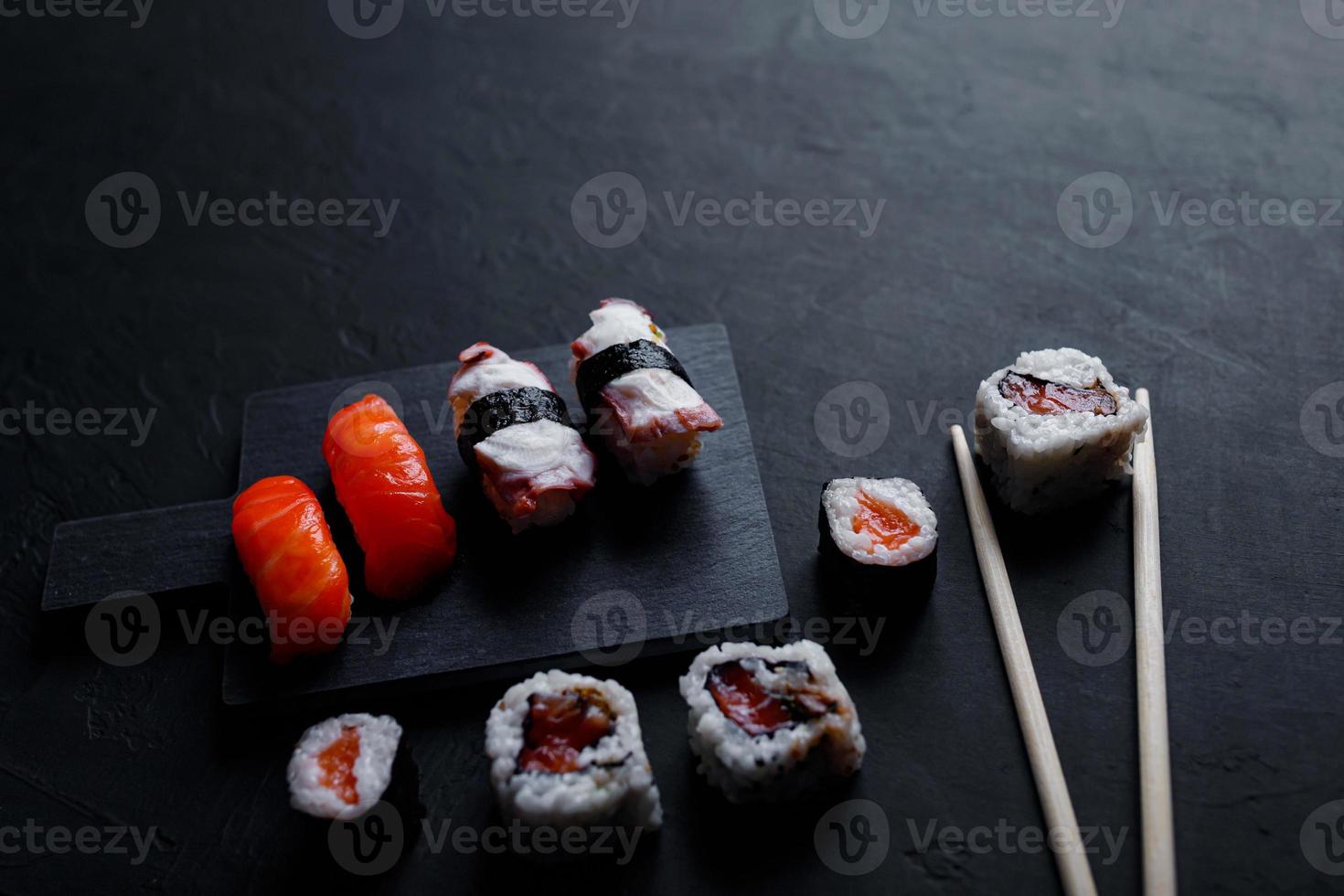 nourriture japonaise de sushi. maki ands rolls au thon, saumon, crevette, crabe et avocat. vue de dessus de sushis assortis. photo