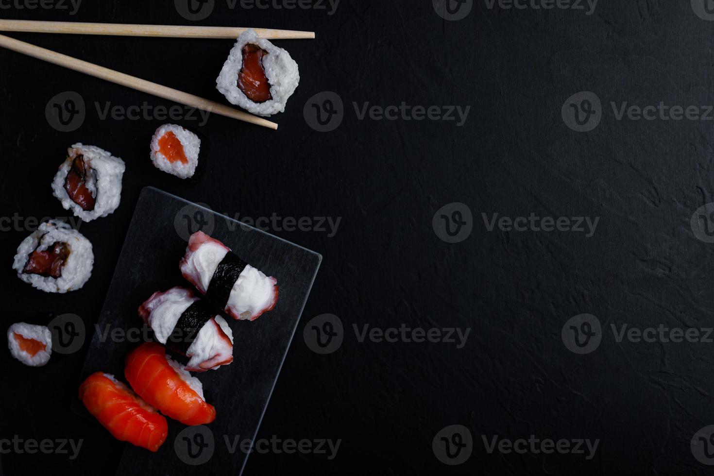 nourriture japonaise de sushi. maki ands rolls au thon, saumon, crevette, crabe et avocat. vue de dessus de sushis assortis. photo