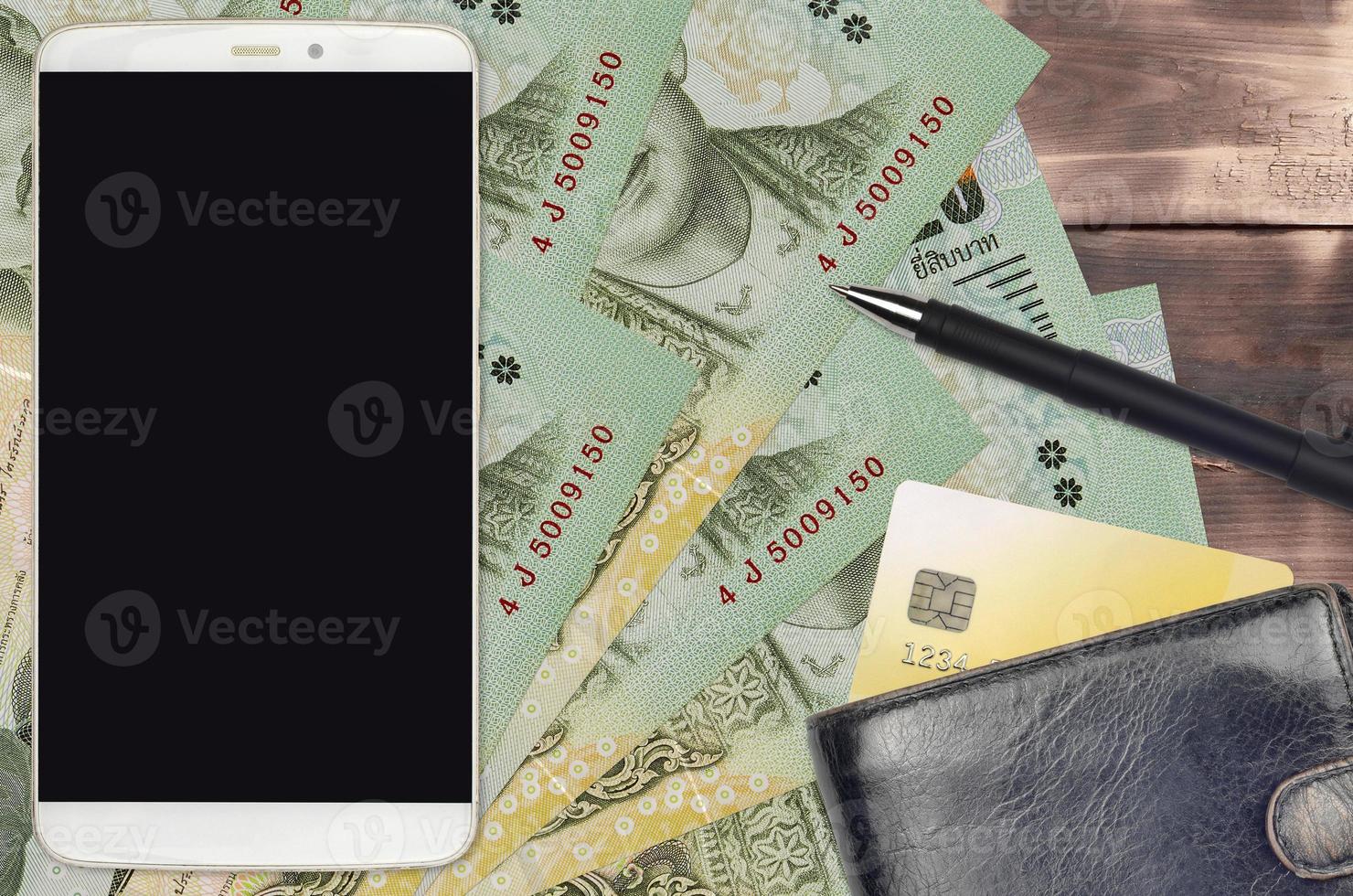 Factures de 20 bahts thaïlandais et smartphone avec sac à main et carte de crédit. paiements électroniques ou concept de commerce électronique. achats en ligne et affaires avec des appareils portables photo