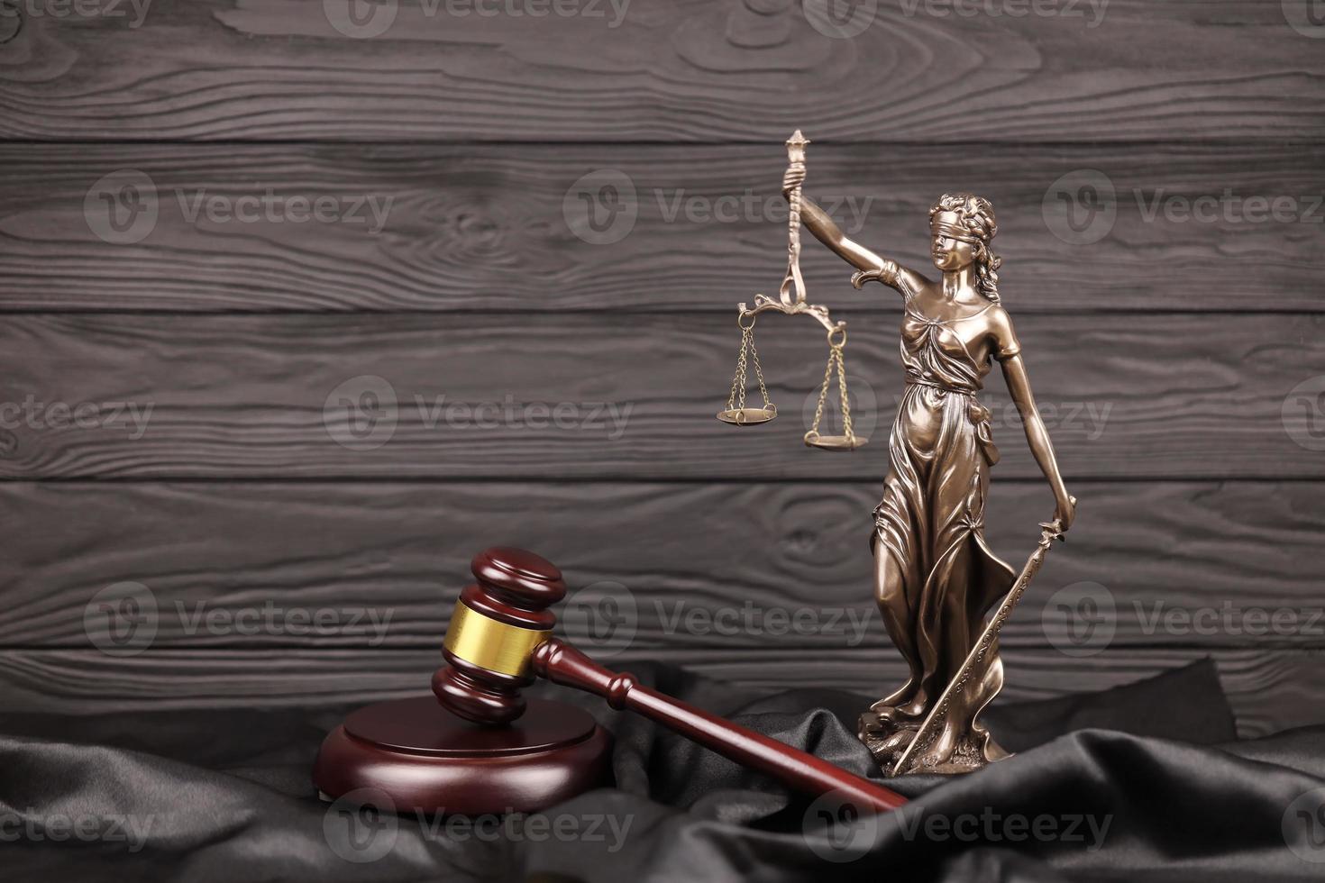 la statue de la justice - dame justice ou justitia la déesse romaine de la justice. statue sur livre brun avec marteau de juge. concept de procès judiciaire, de procédure judiciaire et de travail des avocats photo