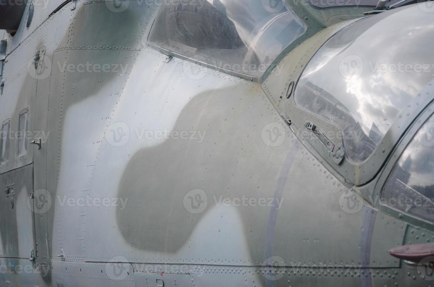 fragment de cabine d'hélicoptère en gros plan. fuselage d'avion de camouflage et verre pare-balles photo