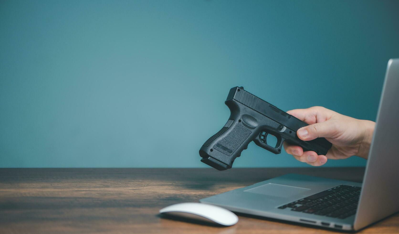 acheter une arme de poing dans une boutique en ligne, les mains du vendeur envoient une arme de poing sur ordinateur pour acheter une arme de poing sur un site Web ou sur les réseaux sociaux. photo