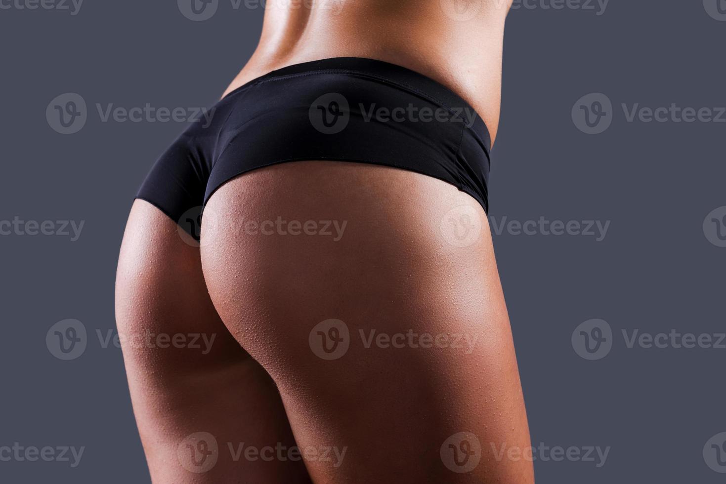 fesses parfaites. gros plan de fesses féminines parfaites sur fond gris photo