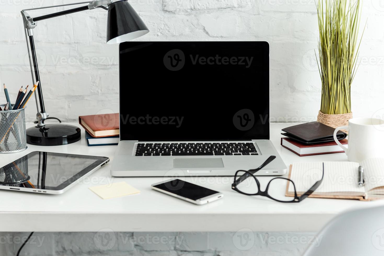 lieu de travail confortable. gros plan sur un lieu de travail confortable au bureau avec une table blanche et un ordinateur portable posé dessus photo