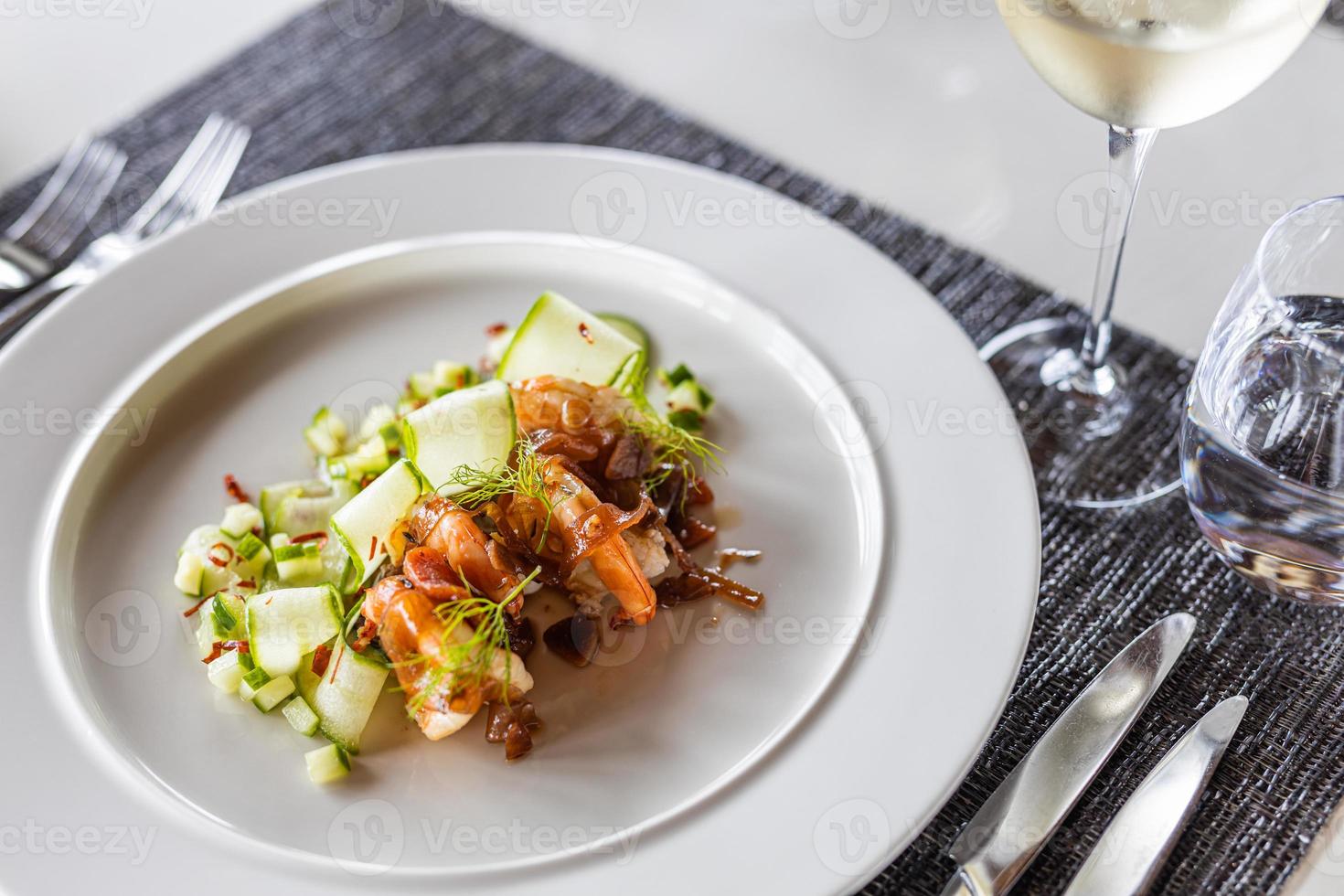 apéritif gastronomique de luxe de rouleaux de concombre aux crevettes et gros plan de légumes sur une élégante assiette blanche. plateau de table horizontal, vin blanc. cuisine salade de dîner luxueuse, repas d'apéritif photo