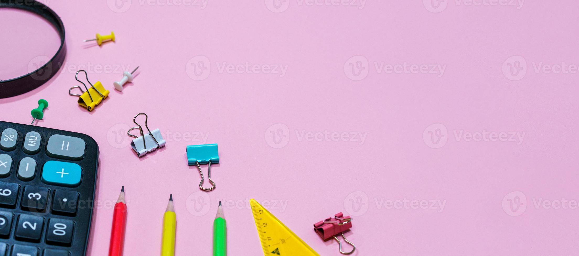 diverses fournitures de bureau sur fond rose. concept de retour à l'école. photo