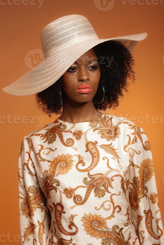 femme afro de mode rétro des années 70 avec robe et chapeau paisley. photo