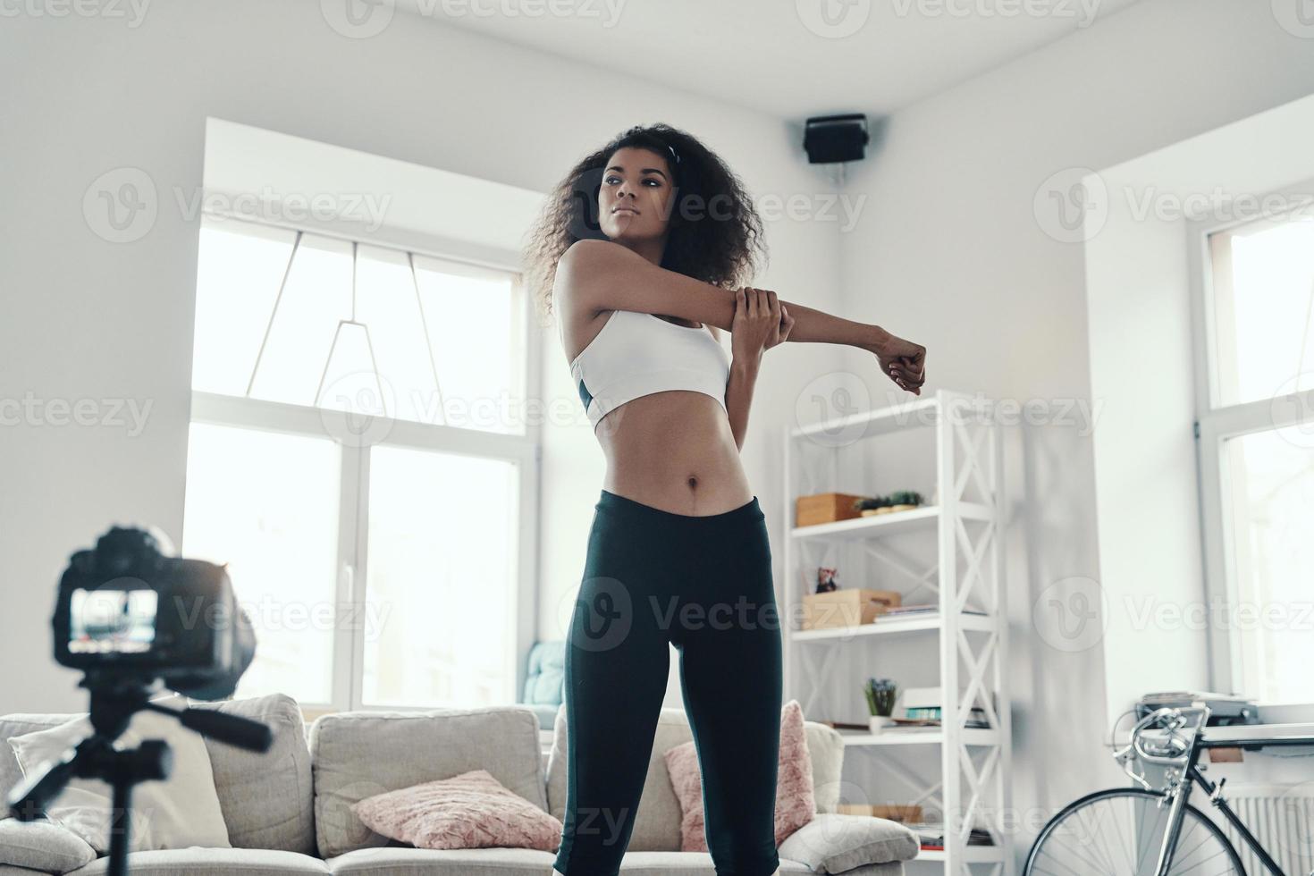 belle jeune femme africaine qui s'étire après un travail acharné tout en faisant une vidéo sur les réseaux sociaux photo