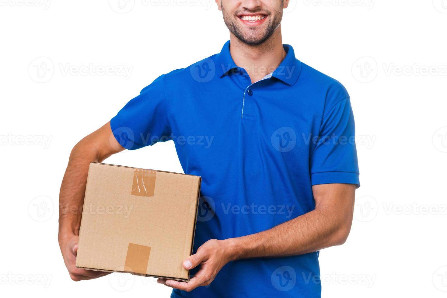 votre colis est entre de bonnes mains. image recadrée d'un jeune coursier tenant une boîte en carton et souriant en se tenant debout sur fond blanc photo