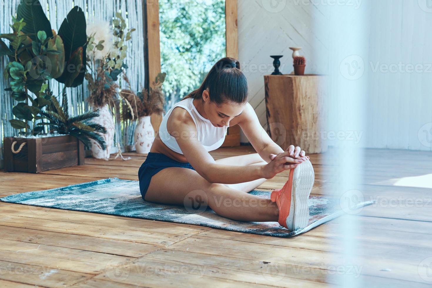 belle jeune femme en vêtements de sport qui s'étend sur le patio photo