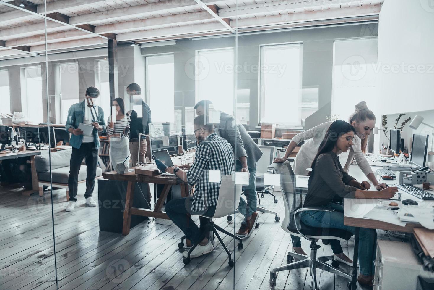 équipe réussie au travail. groupe de jeunes gens d'affaires travaillant et communiquant ensemble dans un bureau créatif photo