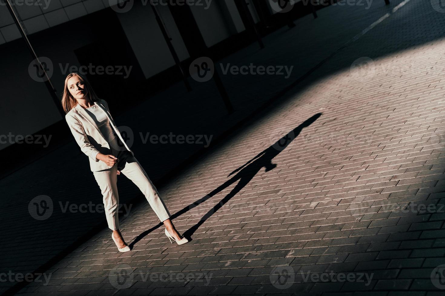 en route vers de nouvelles opportunités. vue de dessus sur toute la longueur d'une jeune femme en costume regardant loin tout en marchant à l'extérieur photo