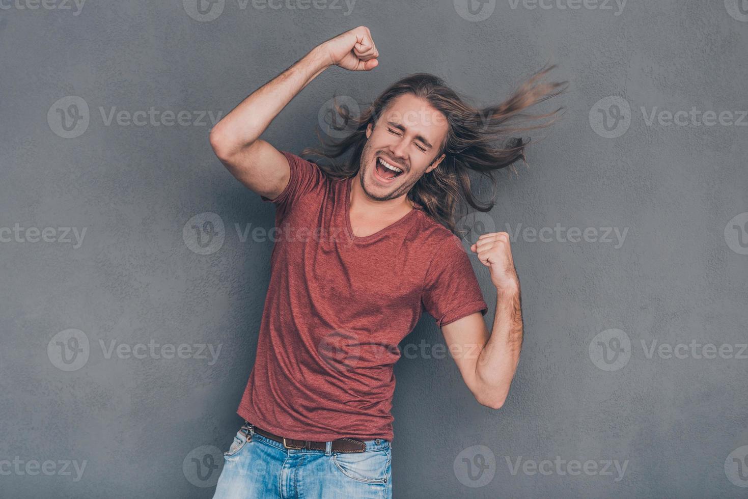 je l'ai fait heureux jeune homme en tenue décontractée debout sur fond gris et gesticulant photo