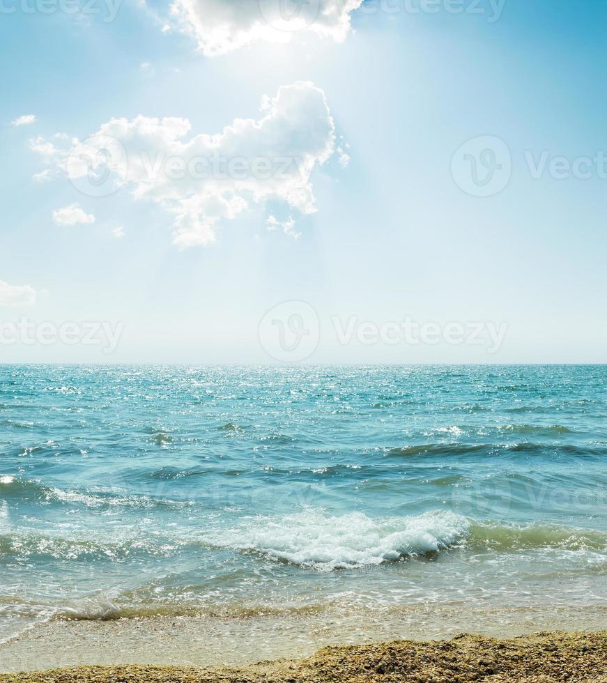 vague sur mer et ciel bleu avec nuages et soleil photo