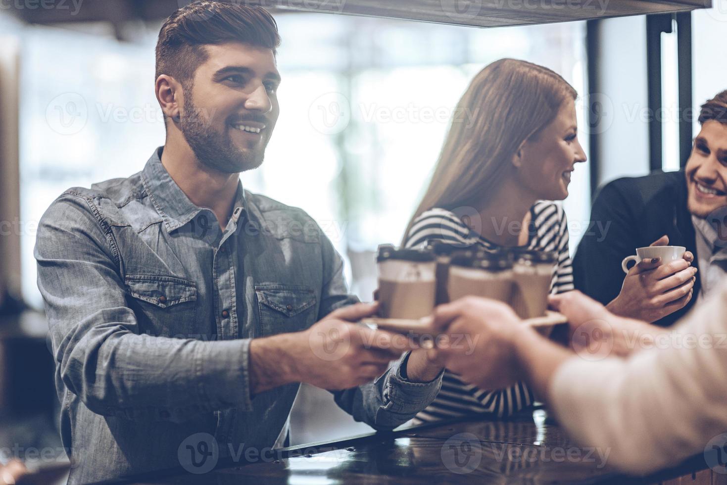 votre café frais est prêt à faire partie du barista qui passe des tasses à café à son client tout en se tenant au comptoir du bar photo