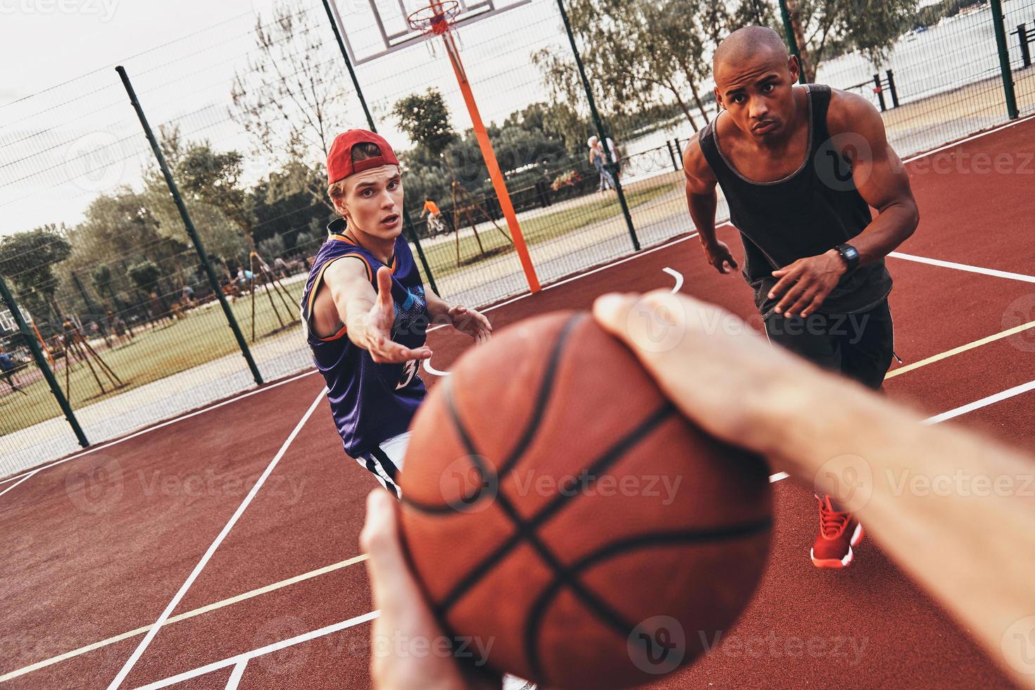 meilleur jeu de tous les temps. gros plan sur un homme tenant un ballon tout en jouant au basket avec des amis à l'extérieur photo