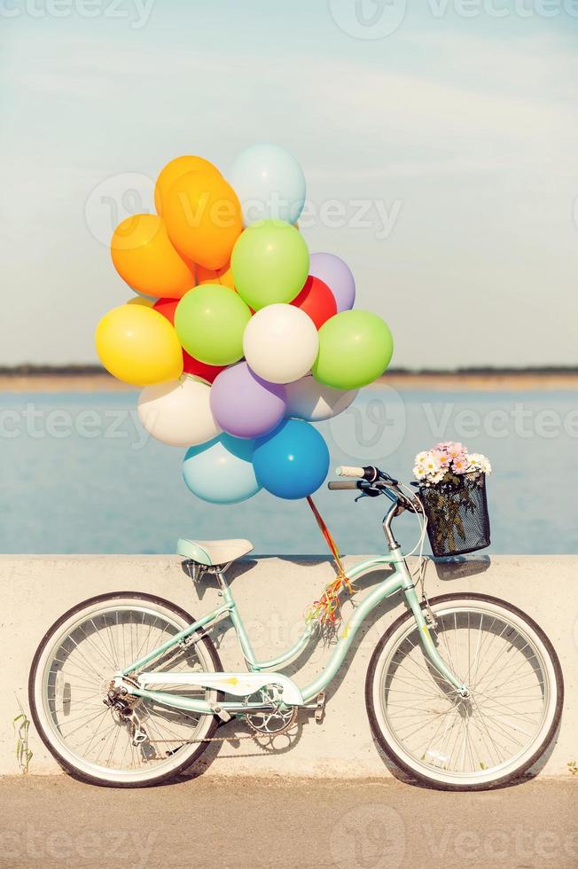 vélo d'été. photo de vélo vintage avec des ballons et des fleurs dans le panier