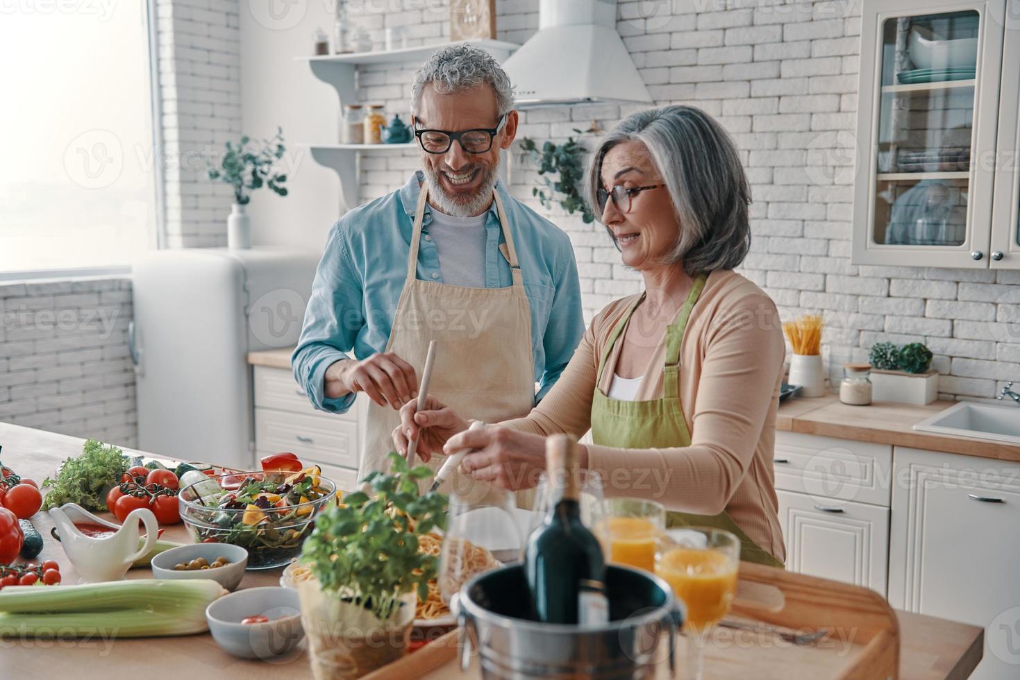 beau couple de personnes âgées en tablier préparant un dîner sain et  souriant tout en passant du temps à la maison 13583437 Photo de stock chez  Vecteezy