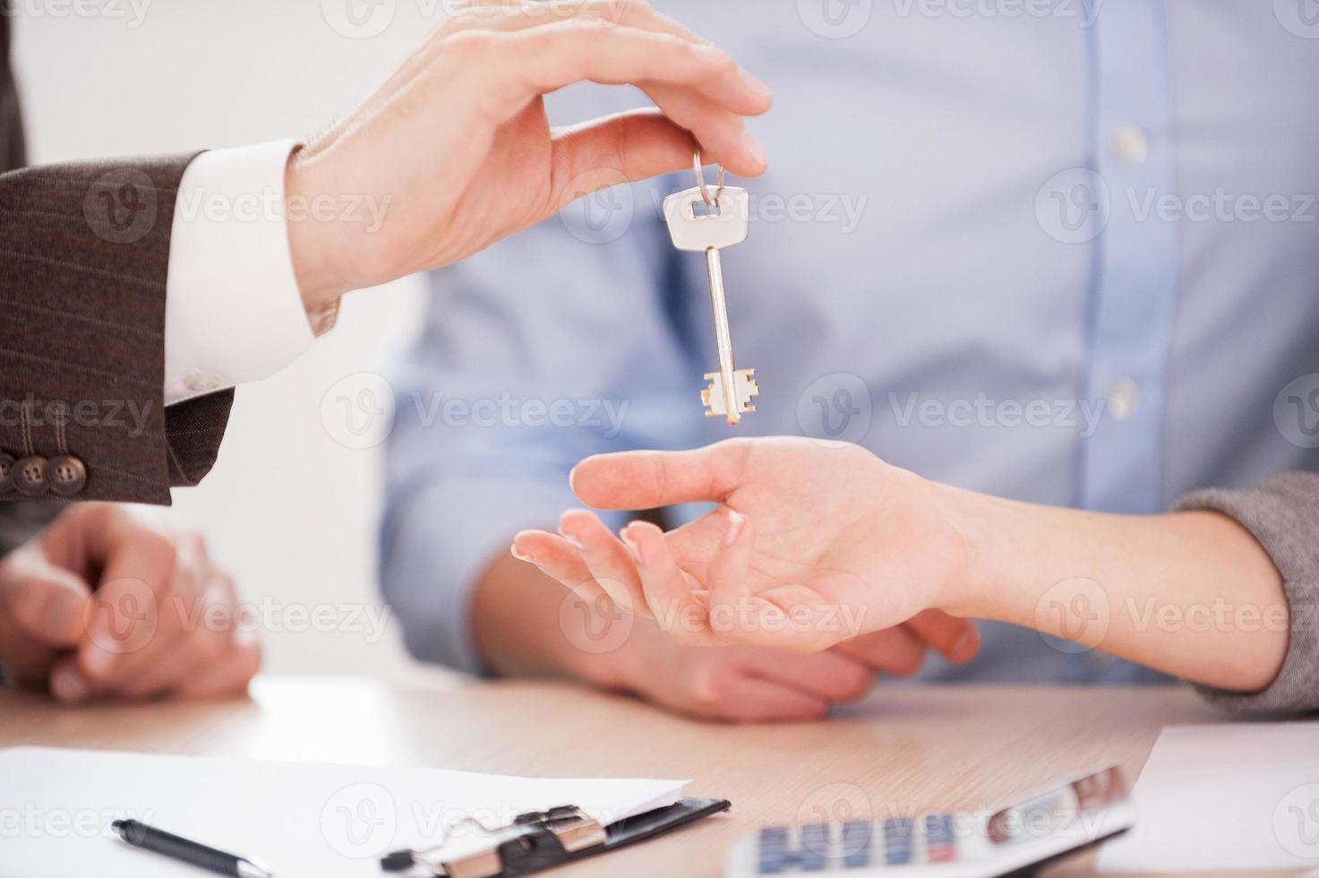 clé de leur nouvelle maison. gros plan, de, homme, dans, formalwear, donner, a, clé, à, a, femme, quoique, séance table photo