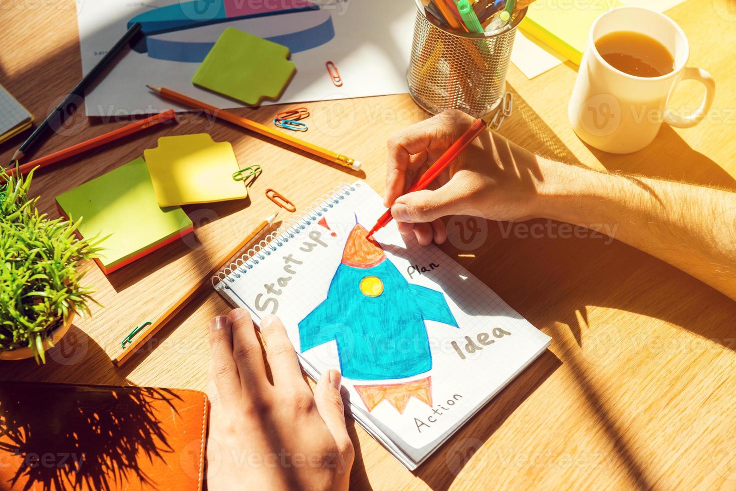 juste inspiré. vue de dessus en gros plan d'un homme esquissant sur papier posé sur le bureau en bois photo