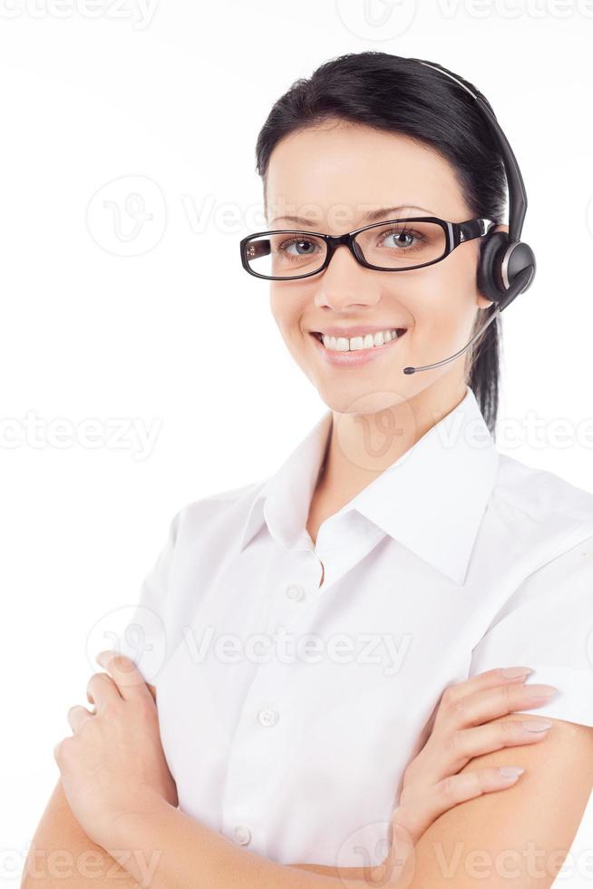 représentant du service à la clientèle. confiante jeune femme dans le casque souriant et gardant les bras croisés tout en se tenant isolé sur blanc photo