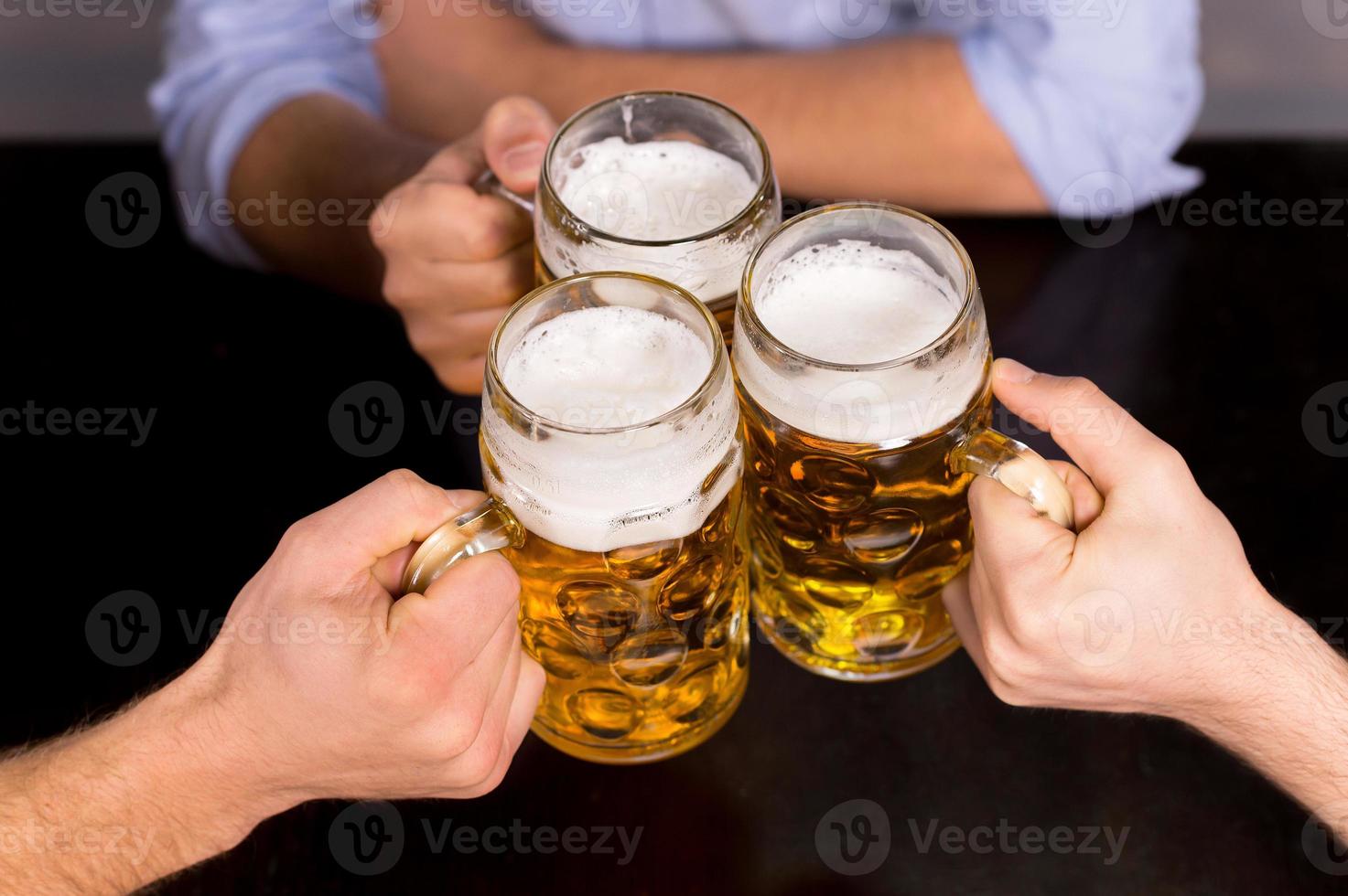 acclamations vue de dessus en gros plan de personnes tenant des chopes avec de la bière photo