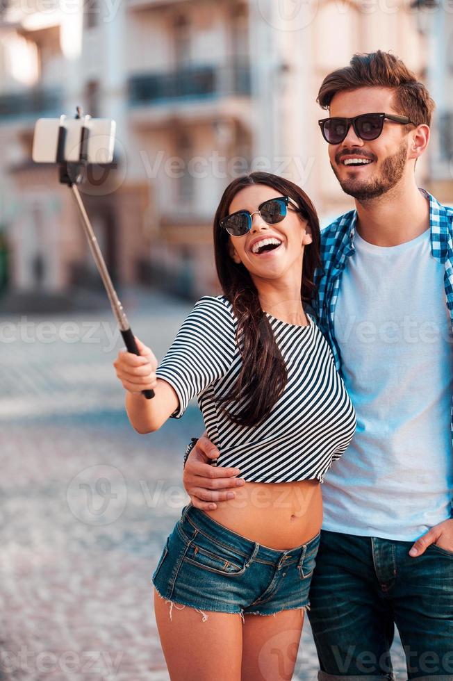 le temps des selfies. joyeux jeune couple d'amoureux faisant selfie sur téléphone intelligent tout en se tenant à l'extérieur photo