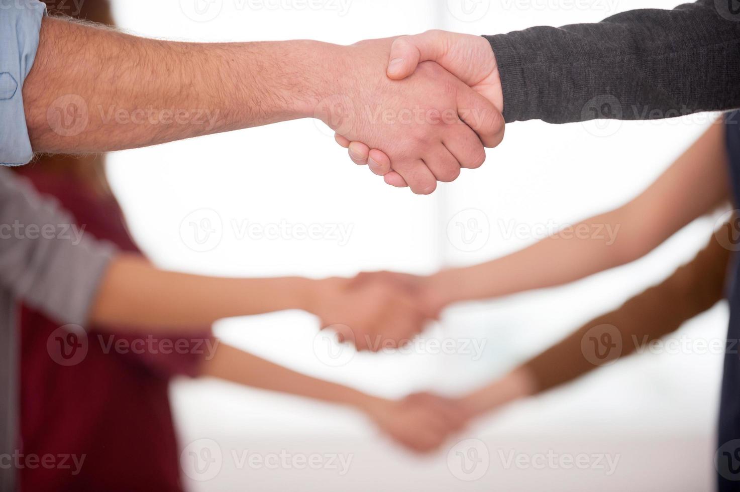 poignée de main. gros plan de personnes se serrant la main en se tenant debout dans une rangée photo