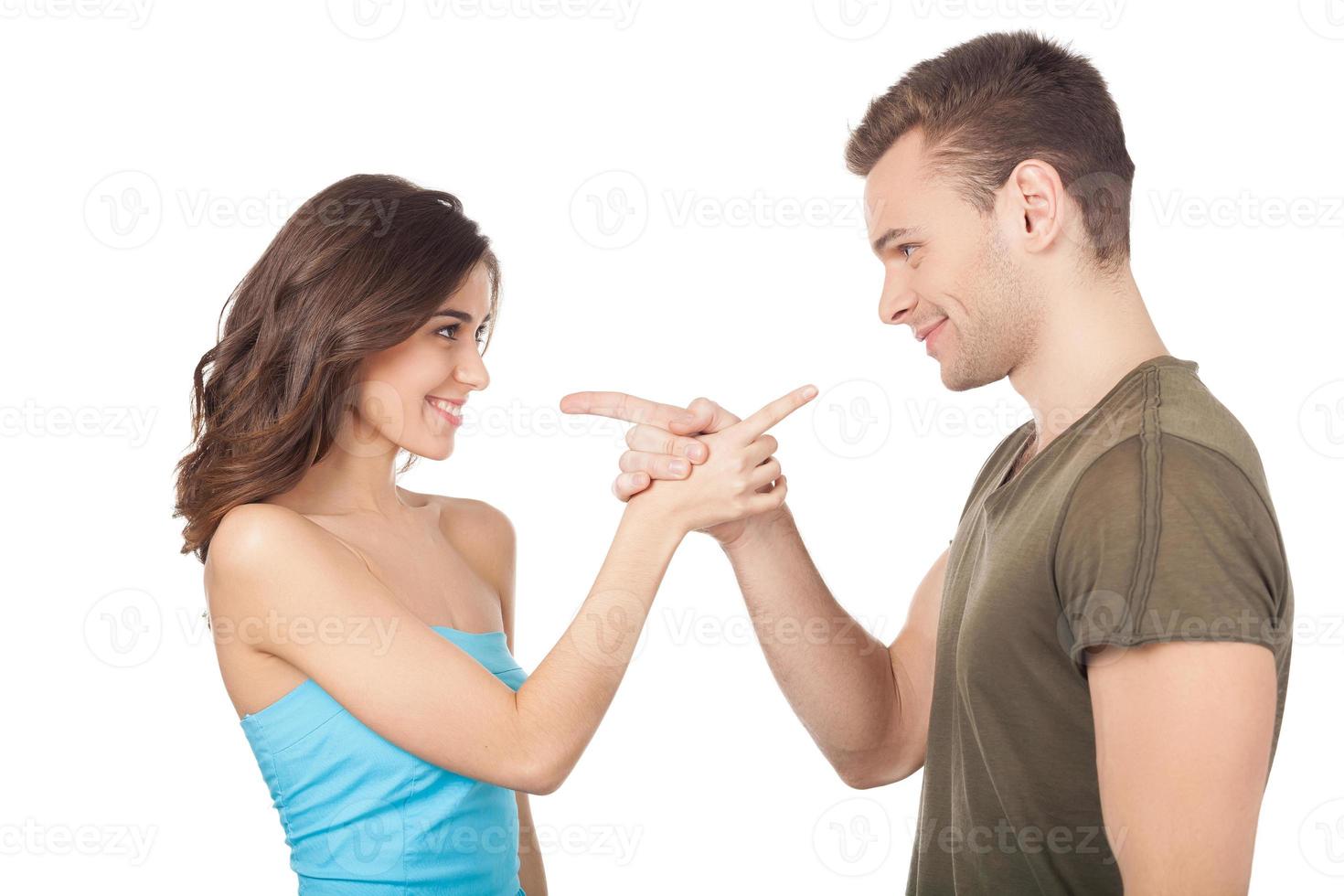 vous joyeux jeune couple pointant l'un l'autre en se tenant debout isolé sur fond blanc photo