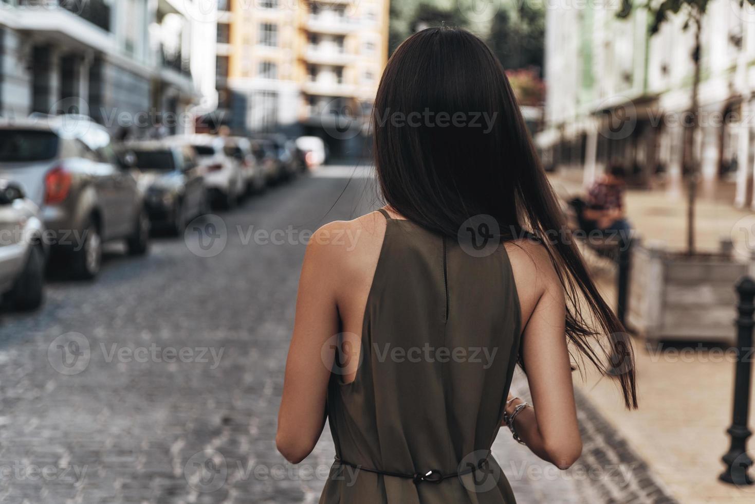 le temps de s'éloigner de tout... vue arrière d'une jeune femme marchant dans la rue tout en passant du temps à l'extérieur photo