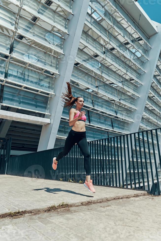 jeune femme confiante en vêtements de sport courant à l'extérieur photo